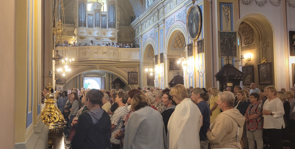 zdjęcie przedstawia ludzi modlących się w kościele