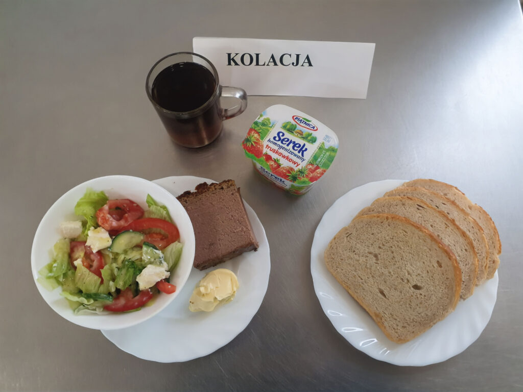 zdjęcie kolacji złożonej z: pasztetu pieczonego, sera topionego, pomidora, chleba, margaryny oraz herbaty.