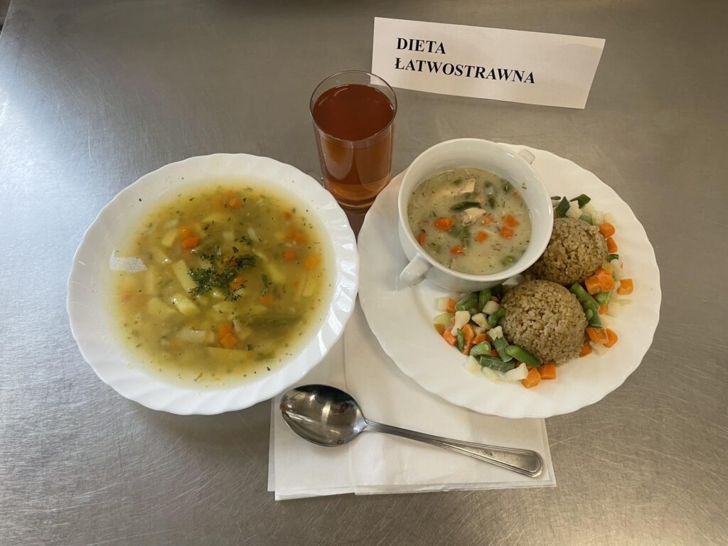 zdjęcie obiadu złożonego z: zupy jarzynowej, potrawki drobiowej, kaszy jęczmiennej oraz kompotu.