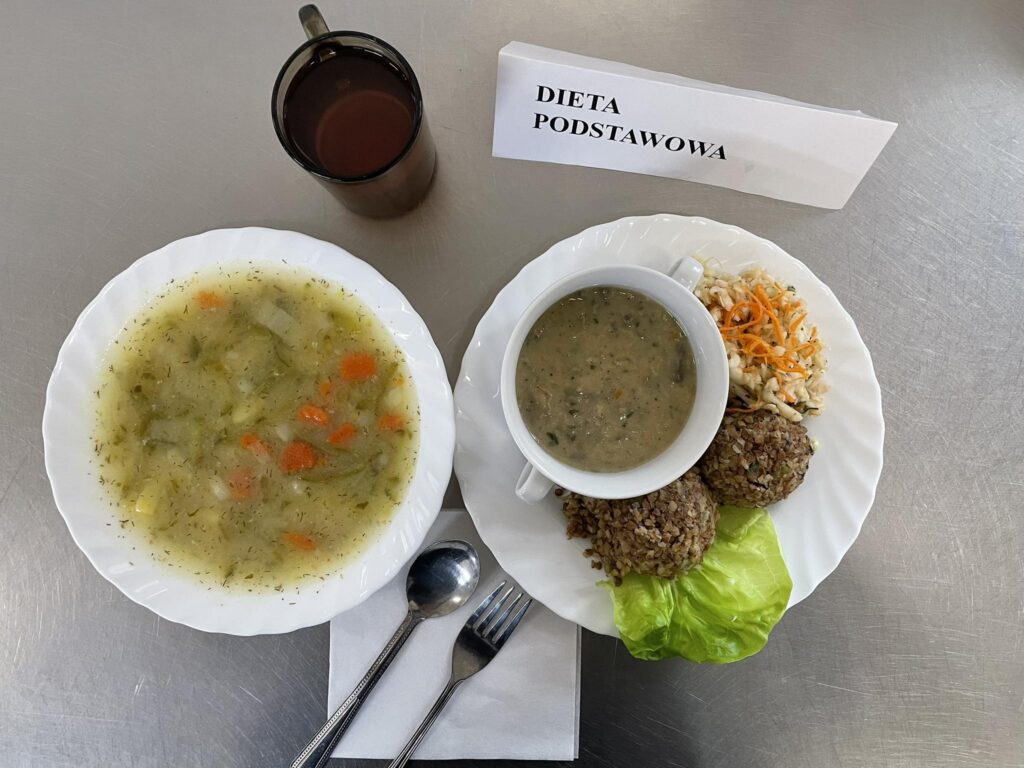 zdjęcie obiadu złożonego z: zupy ogórkowej z ziemniakami, kaszotta z mięsem, sosu pieczarkowego oraz kompotu.