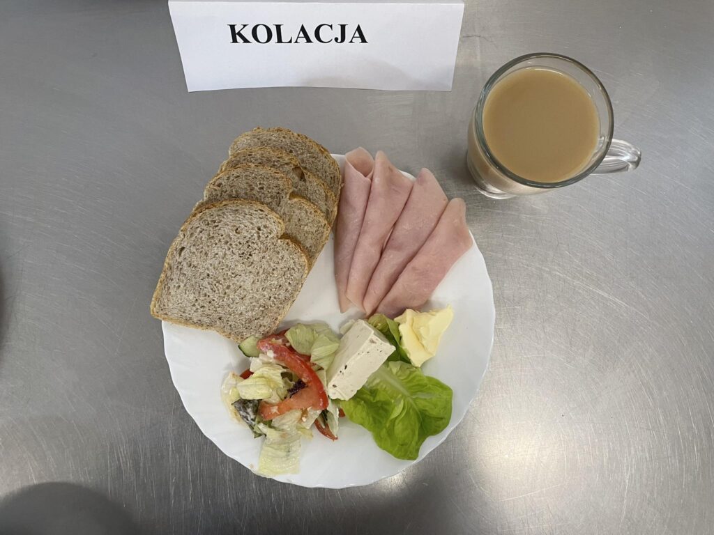 zdjęcie kolacji złożonej z: sera topionego, sałaty, szynki, chleba, margaryny oraz herbaty.