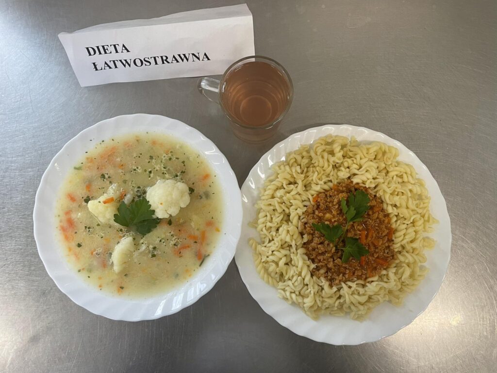 zdjęcie obiadu złożonego z: zupy kalafiorowej z ziemniakami, makaronu, sosu bolognese oraz kompotu.