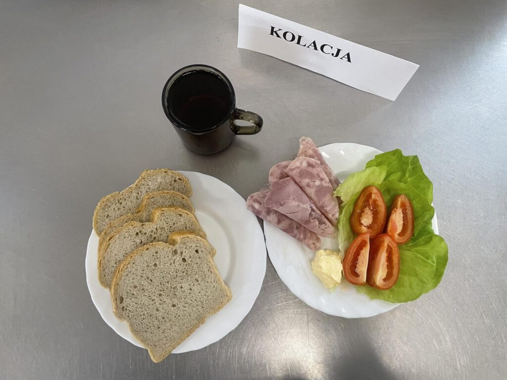 zdjęcie kolacji złożonej z: konserwy wojskowej, pomidora, chleba, margaryny oraz herbaty.