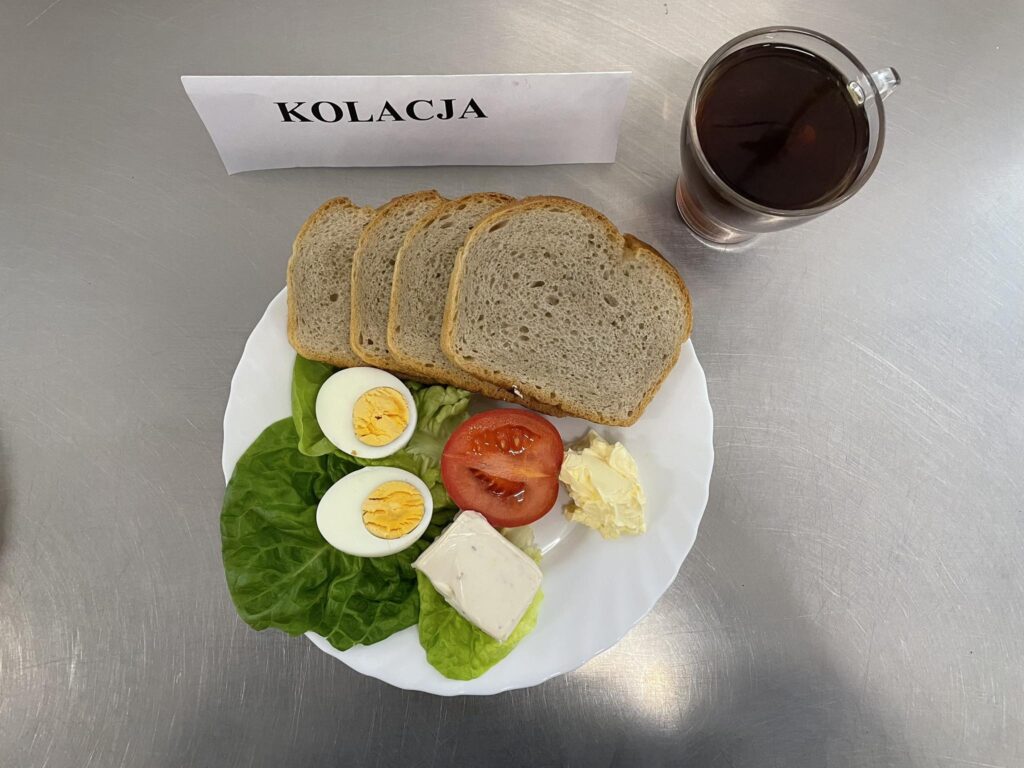 zdjęcie kolacji złożonej z: sera topionego, pomidora, chleba, margaryny oraz herbaty.