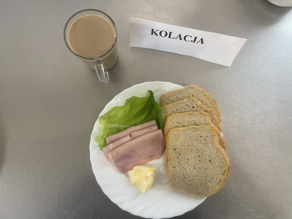 zdjęcie kolacji złożonej z: polędwicy drobiowej, sałatki wiosennej, chleba, margaryny oraz kawy z mlekiem.