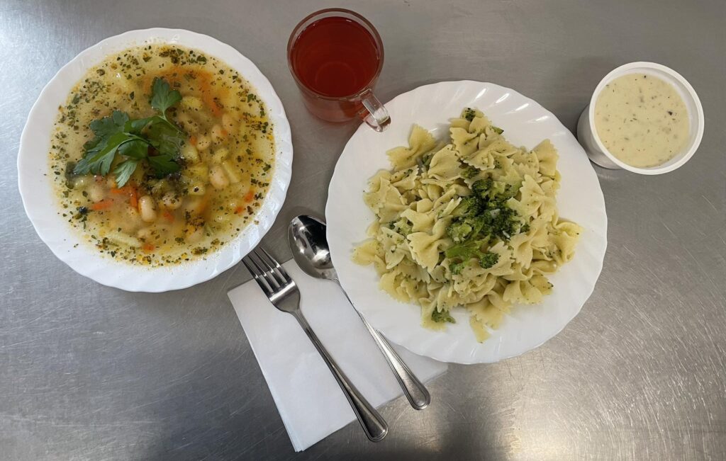 zdjęcie obiadu złożonego z: zupy fasolowej z ziemniakami, makaronu ze świeżym brokułem, szpinakiem, sosem serowo-koperkowym oraz kompotu. 