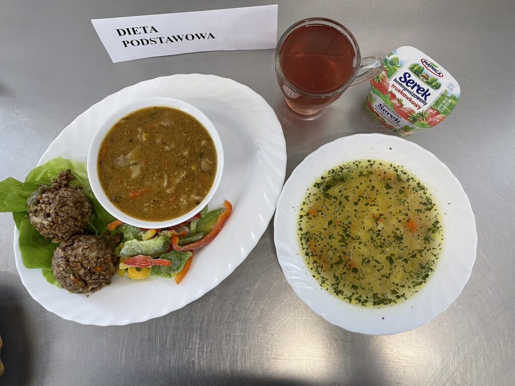 zdjęcie obiadu złożonego z; zupy jarzynowej, kaszotta z kaszy gryczanej z warzywami, gulaszem, kompotem oraz serkiem homogenizowanym.