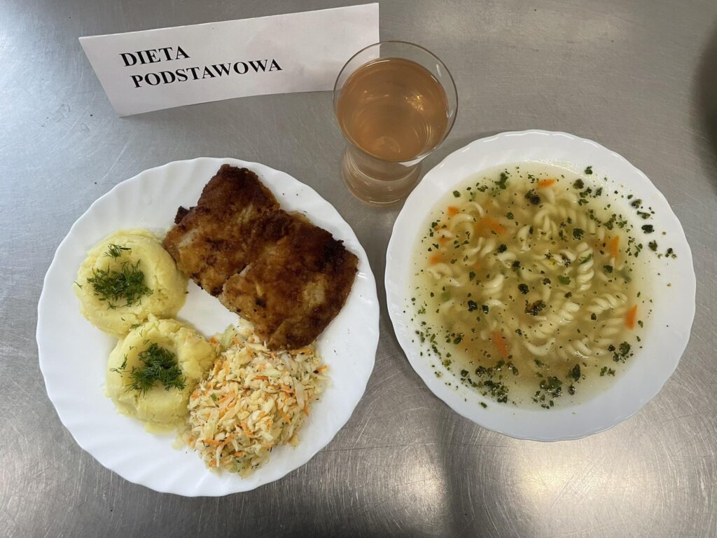 zdjęcie obiadu złożonego z: zupy fasolowej z makaronem, ryby panierowanej, ziemniaków, kapusty kiszonej oraz kompotu.