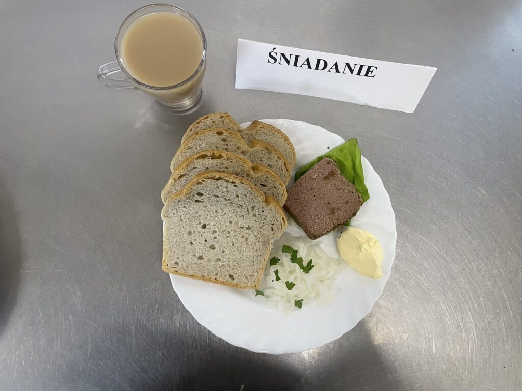 zdjęcie śniadania złożonego z: pasztetu pieczonego, rzodkiewki białej, chleba, margaryny oraz kawy z mlekiem.