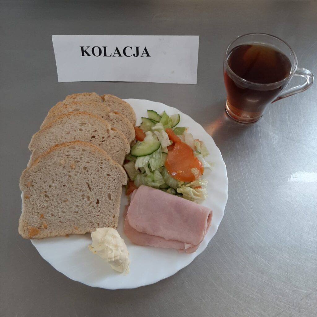 zdjęcie kolacji złożonej z: polędwicy drobiowej, sałatki wiosennej, chleba, margaryny oraz herbaty.