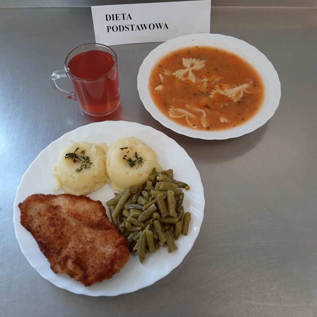 zdjęcie obiadu złożonego z: zupy pomidorowej z makaronem, kotleta drobiowego, ziemniaków, fasoli szparagowej oraz kompotu.