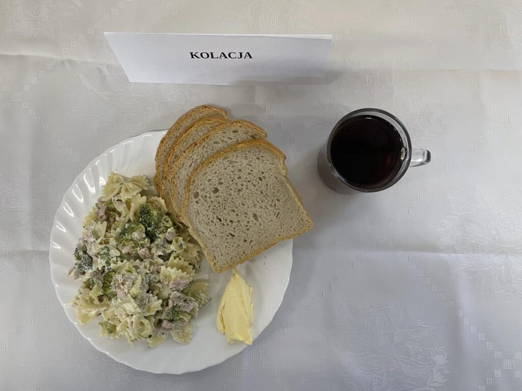 Zdjęcie kolacji złożonej z: sałatki brokułowej, szynki konserwowej, chleba, margaryny oraz herbaty.