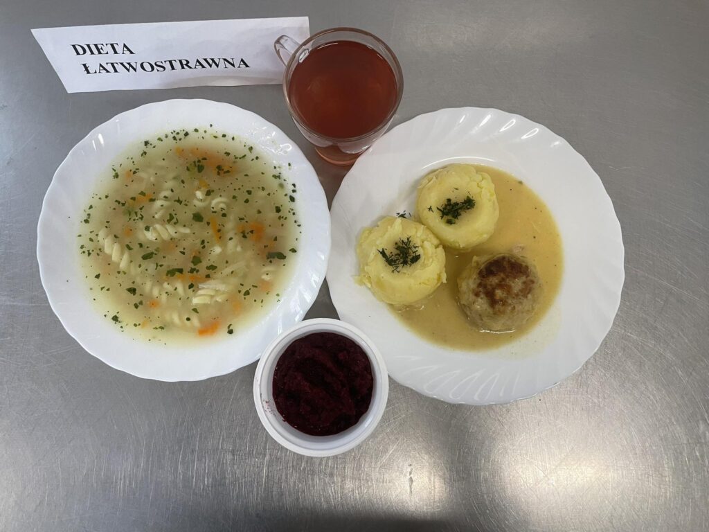 Zdjęcie obiadu złożonego z: zupy koperkowej z makaronem, pulpeta w sosie chrzanowym, ziemniaków, ćwikły oraz kompotu.