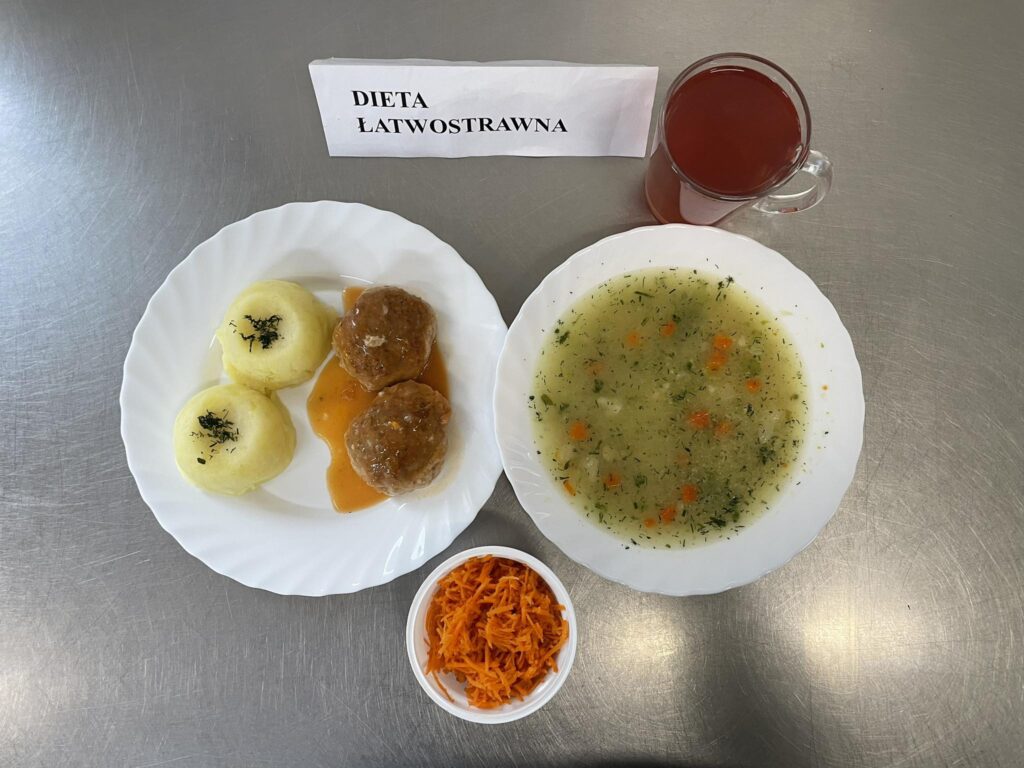 obiad złożony z: zupy koperkowej z ryżem, pulpeta w sosie pomidorowym, surówki z marchwi i jabłka, ziemniaków oraz kompotu.