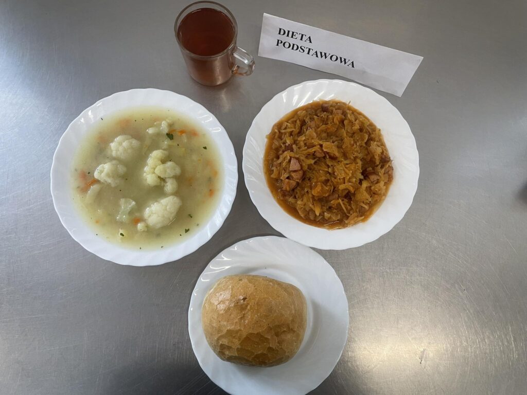 zdjęcie obiadu składającego się z: zupy kalafiorowej z ziemniakami, bigosu, bułki oraz kompotu.