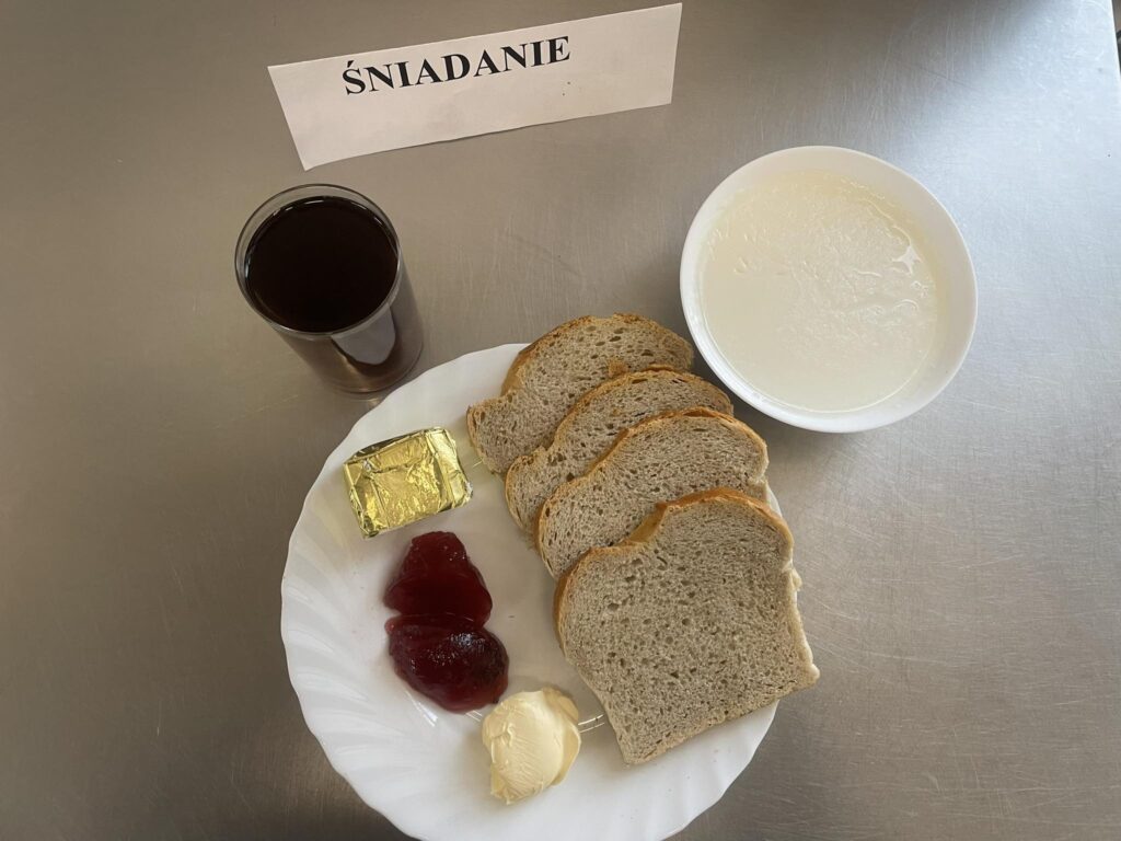 zdjęcie śniadania złożonego z: ryżu na mleku, sera topionego, chleba, margaryny oraz herbaty.