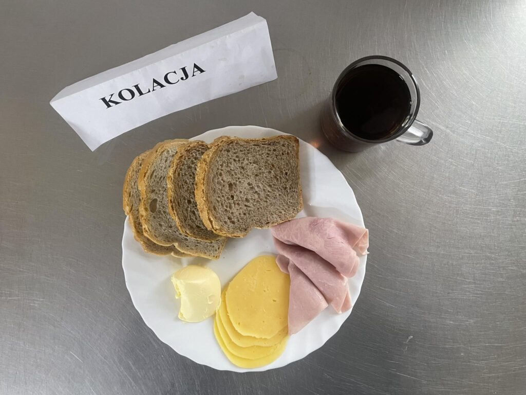 kolacja złożona z: chleba mazowieckiego, chleba razowego, margaryny śniadaniowej, sera edamskiego, tłustego, ogórka oraz herbaty.