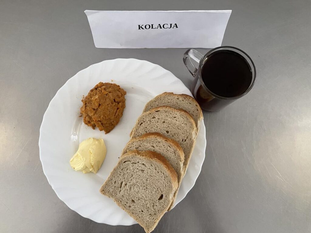 kolacja złożona z: chleba pszennego, chleba razowego, margaryny śniadaniowej, paprykarza szczecińskiego, sałaty oraz herbaty czarnej (napar z cukrem).