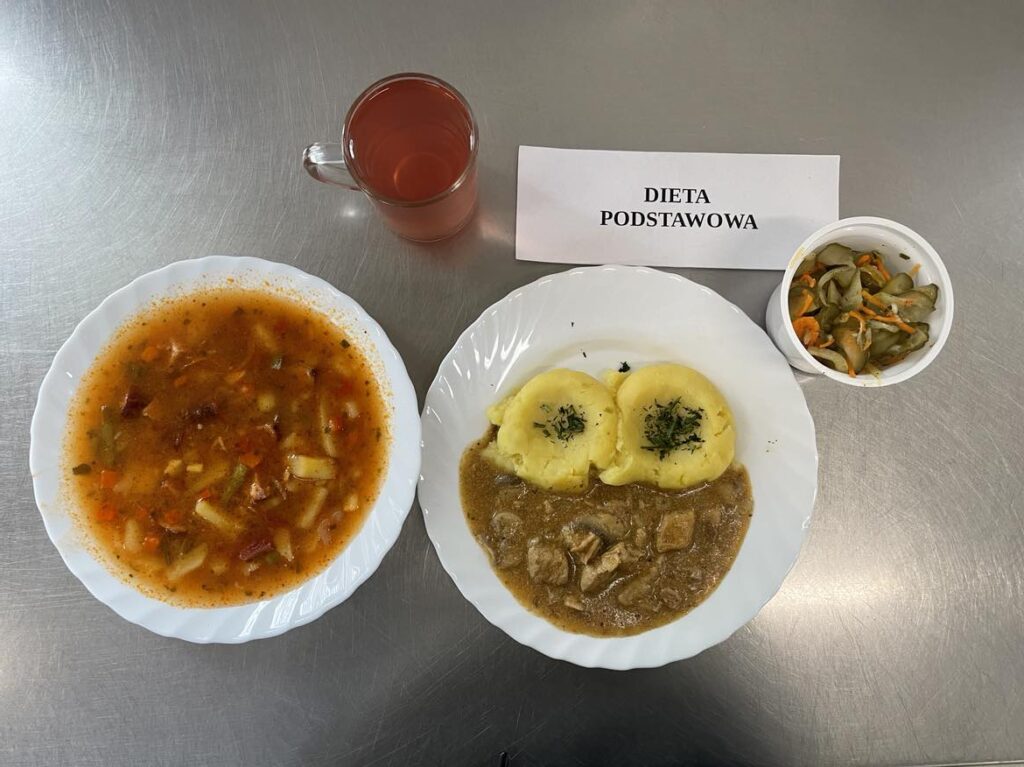 Obiad złożony z: Ziemniaki Puree, ogórki kiszone, gulasz wieprzowy z warzywami, meksykańska zupa oraz kompot z jabłek z cukrem.
