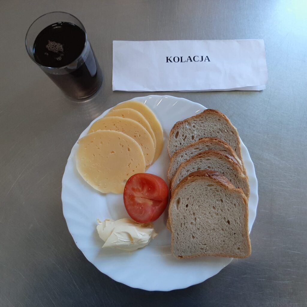 kolacja złożona z: chleba pszennego, margaryny śniadaniowej, herbaty czarnej (napar z cukru), sera edamskiego oraz pomidora.