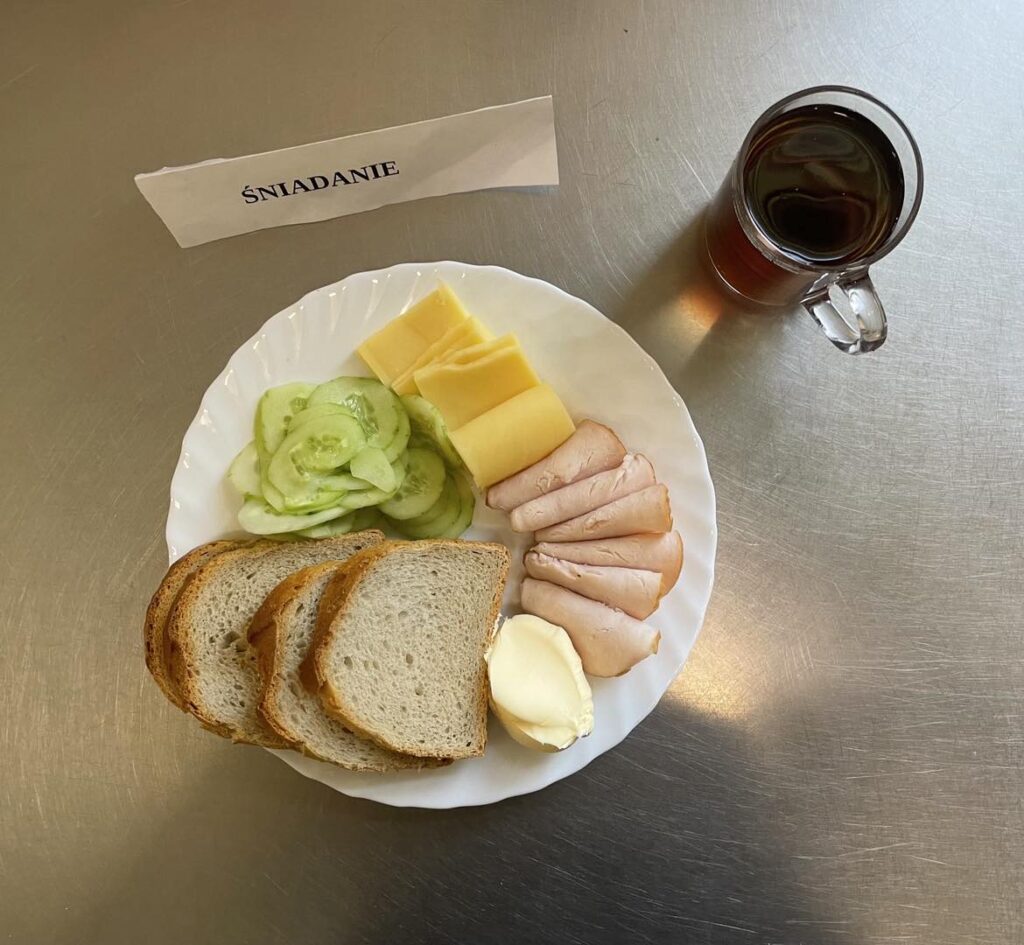 Śniadanie złożone z: chleba pszennego, margaryny śniadaniowej, sera edamskiego (tłustego), szynki wieprzowej, ogórka oraz herbaty czarnej 9napar z cukrem). 