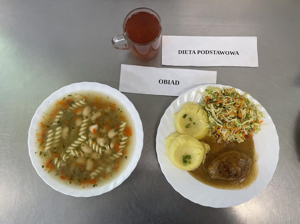 Obiad złożony z: zupy fasolowej, ziemniaków puree, zrazy wieprzowej, duszonej młodej kapusty z koperkiem i marchewką oraz kompot jabłkowy (bez cukru). 