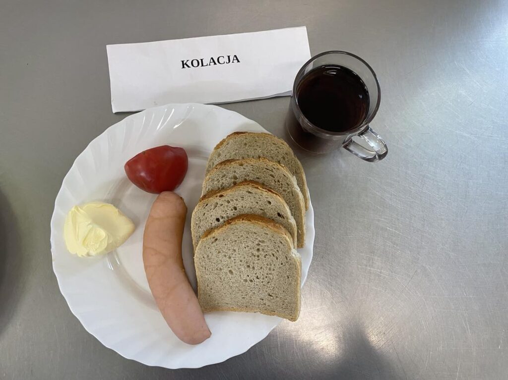 kolacja złożona z: chleba pszennego, margaryny śniadaniowej, szynki kanapkowej, pomidora oraz herbaty czarnej (napar bez cukru).