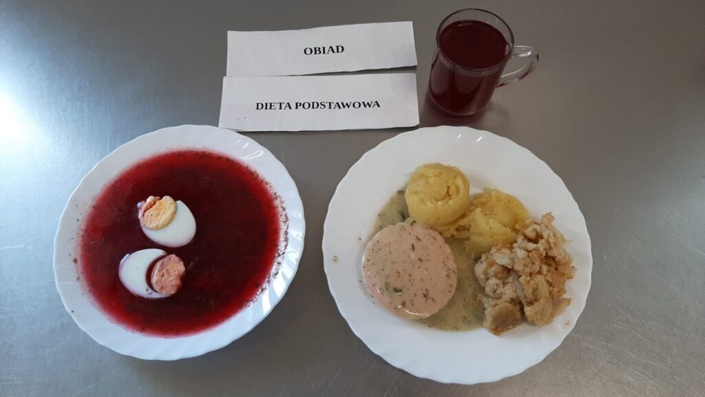 Obiad złożony z: ziemniaki puree, karkówki duszonej w sosie, kalafiora, kompotu z jabłek (z cukrem) oraz barszcz z botwinki z jajkiem.