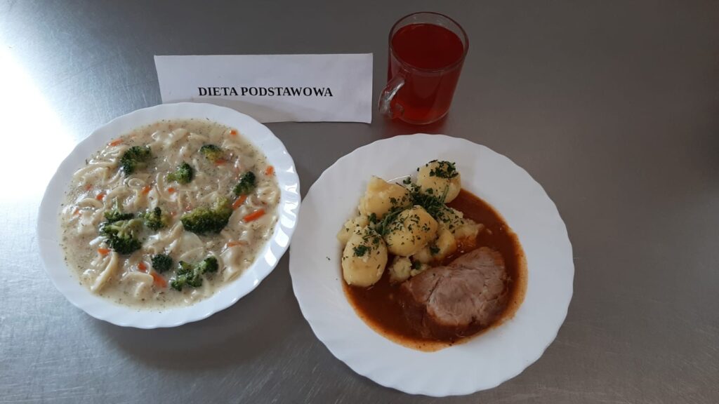 Obiad złożony z: zupy kalafiorowej, ziemniaków puree, karkówki duszonej, mizeri oraz kompotu z jabłek (z cukrem).