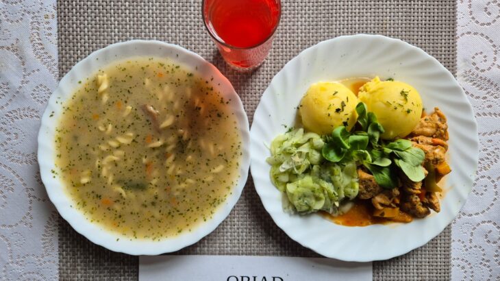 Na zdjęciu znajduję się posiłek w którego skład wchodzi Zupa pieczarkowa z makaronem, Ziemniaki gotowane, filet z indyka w sosie paprykowym, mizeria z octem oraz Kompot z jabłek