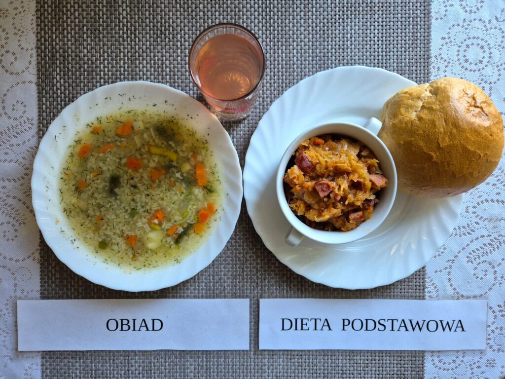 Na zdjęciu znajduję się posiłek w którego skład wchodzi Zupa koperkowa, Bigos, Bułka pszenna oraz kompot