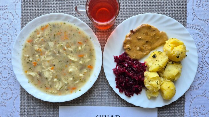 Na zdjęciu znajduję się posiłek w którego skład wchodzi Zupa pieczarkowa z makaronem, Ziemniaki, Bitka wieprzowa, Kalafior z bułka tartą oraz Kompot z jabłek