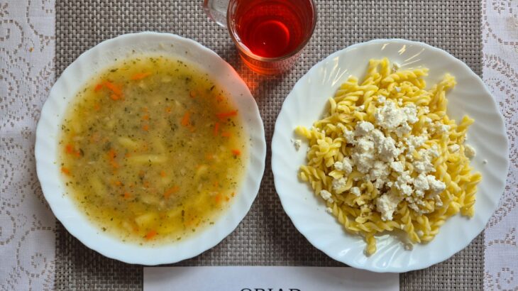 Na zdjęciu znajduję się posiłek w którego skład wchodzi Zupa grochowa z ziemniakami, Makaron z białym serem oraz kompot z jabłek