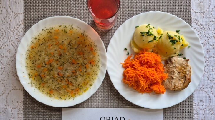 Na zdjęciu znajduję się posiłek w którego skład wchodzi Zupa koperkowa, Ziemniaki, Schab pieczony w sosie własnym, surówka z marchewki oraz kompot