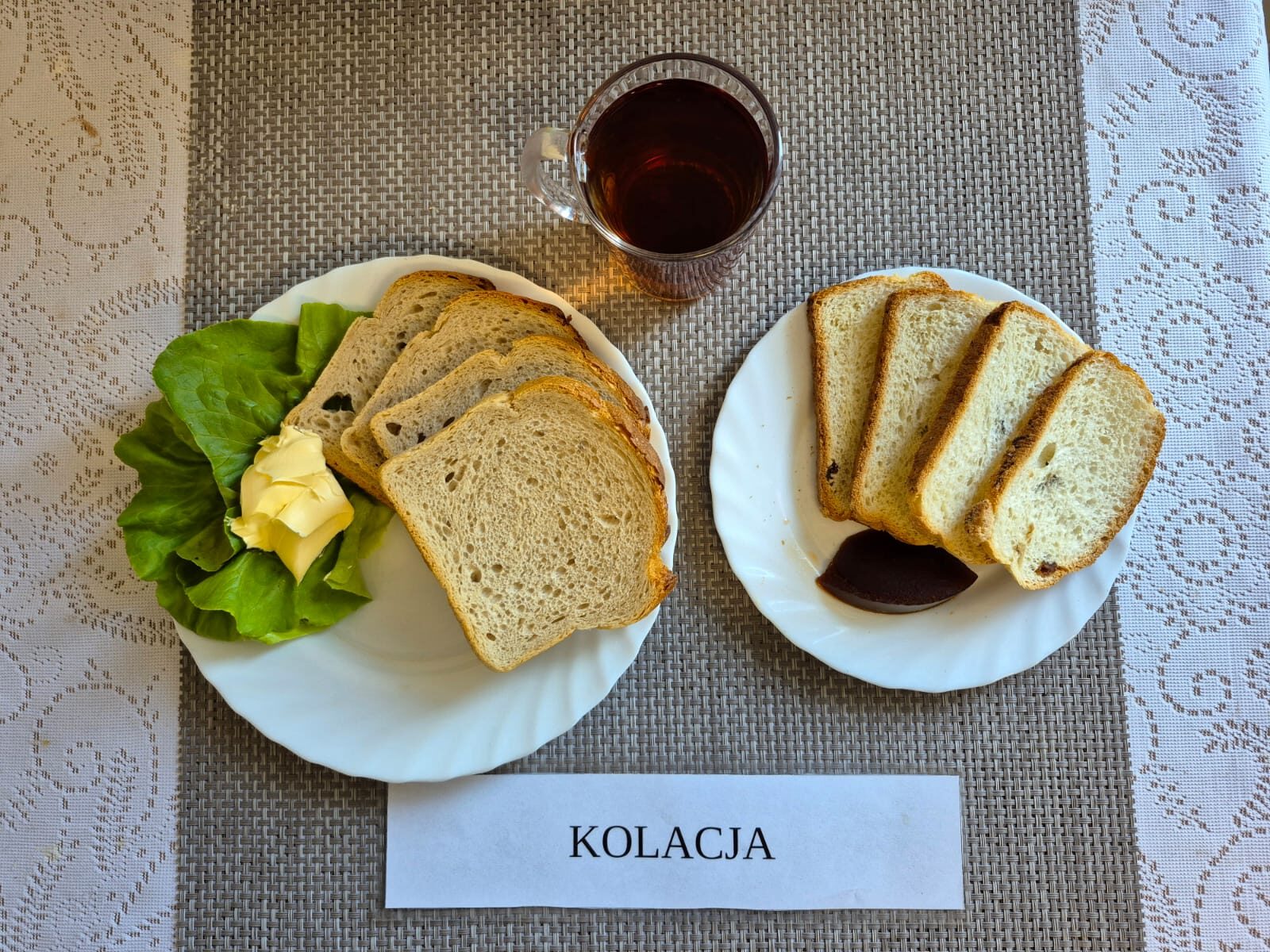 Na zdjęciu znajduję się posiłek w którego skład wchodzi Chleb pszenny, Margaryna Śniadaniowa, paprykarz szczeciński, Sałata masłowa, Pomidor oraz herbata