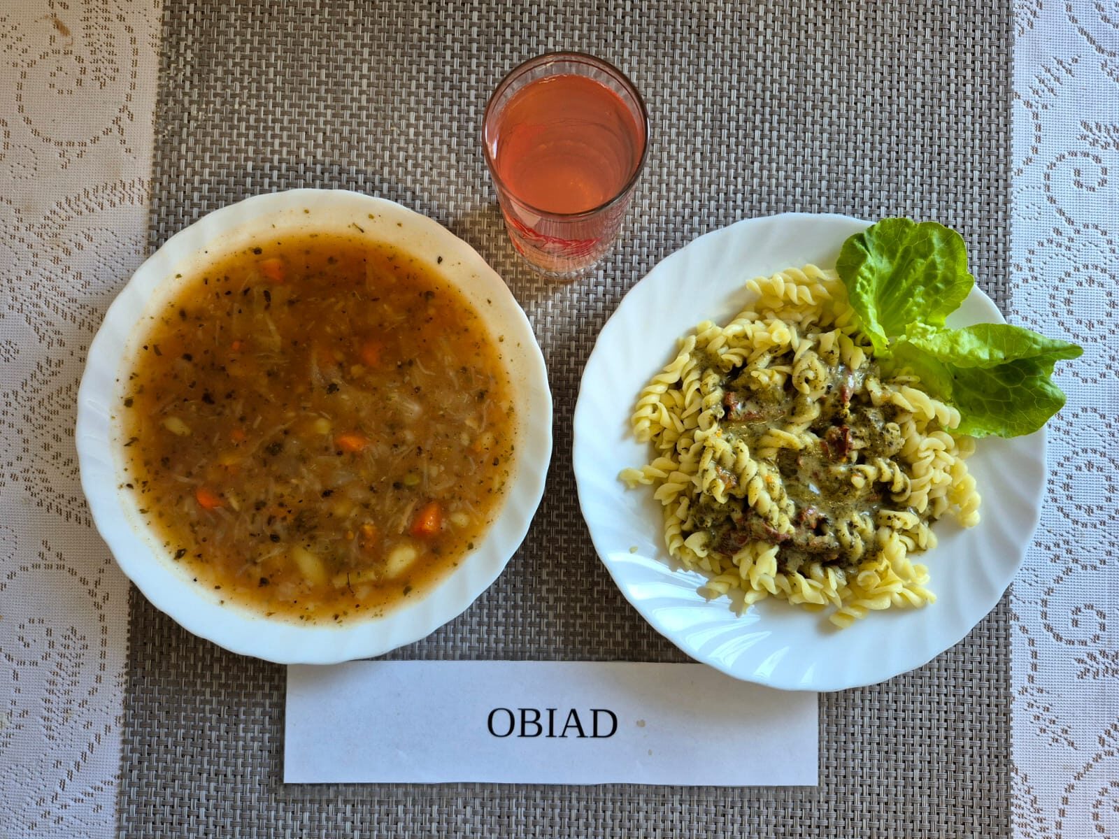 Na zdjęciu znajduję się posiłek w którego skład wchodzi Zupa kapuśniak z ziemniakami, Makaron z sosem śmietanowym z suszonymi pomidorami i szpinakiem, Jabłko, kompot z jabłek