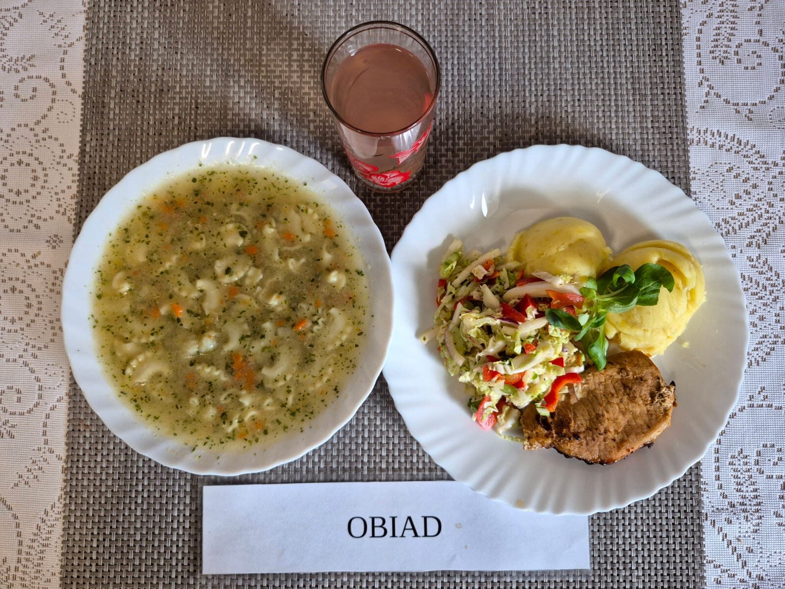 Na zdjęciu znajduję się posiłek w którego skład wchodzi Zupa kalafiorowa z makaronem, Ziemniaki, Schab pieczony, sos pieczarkowy, Surówka z kapusty pekińskiej z papryką oraz Kompot z jabłek