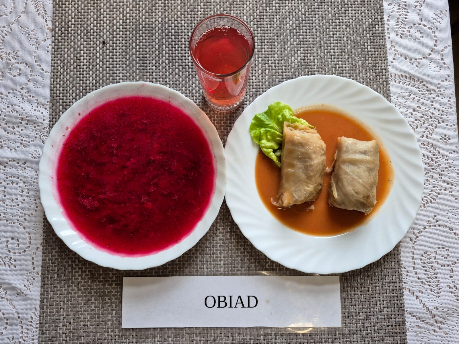 Na zdjęciu znajduję się posiłek w którego skład wchodzi Zupa barszcz ukraiński z ziemniakami, Gołąbki z sosem pomidorowym oraz kompot z jabłek