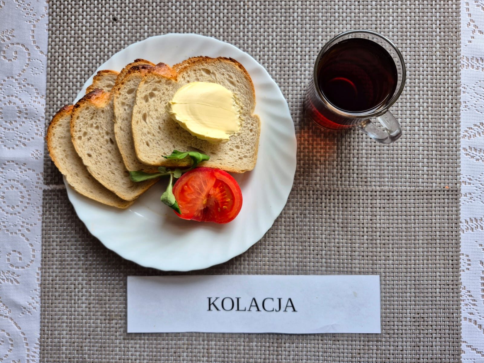 Na zdjęciu znajduję się posiłek w którego skład wchodzi Chleb pszenny, Margaryna Śniadaniowa, Kiełbasa krakowska drobiowa, sałata masłowa oraz Herbata czarna