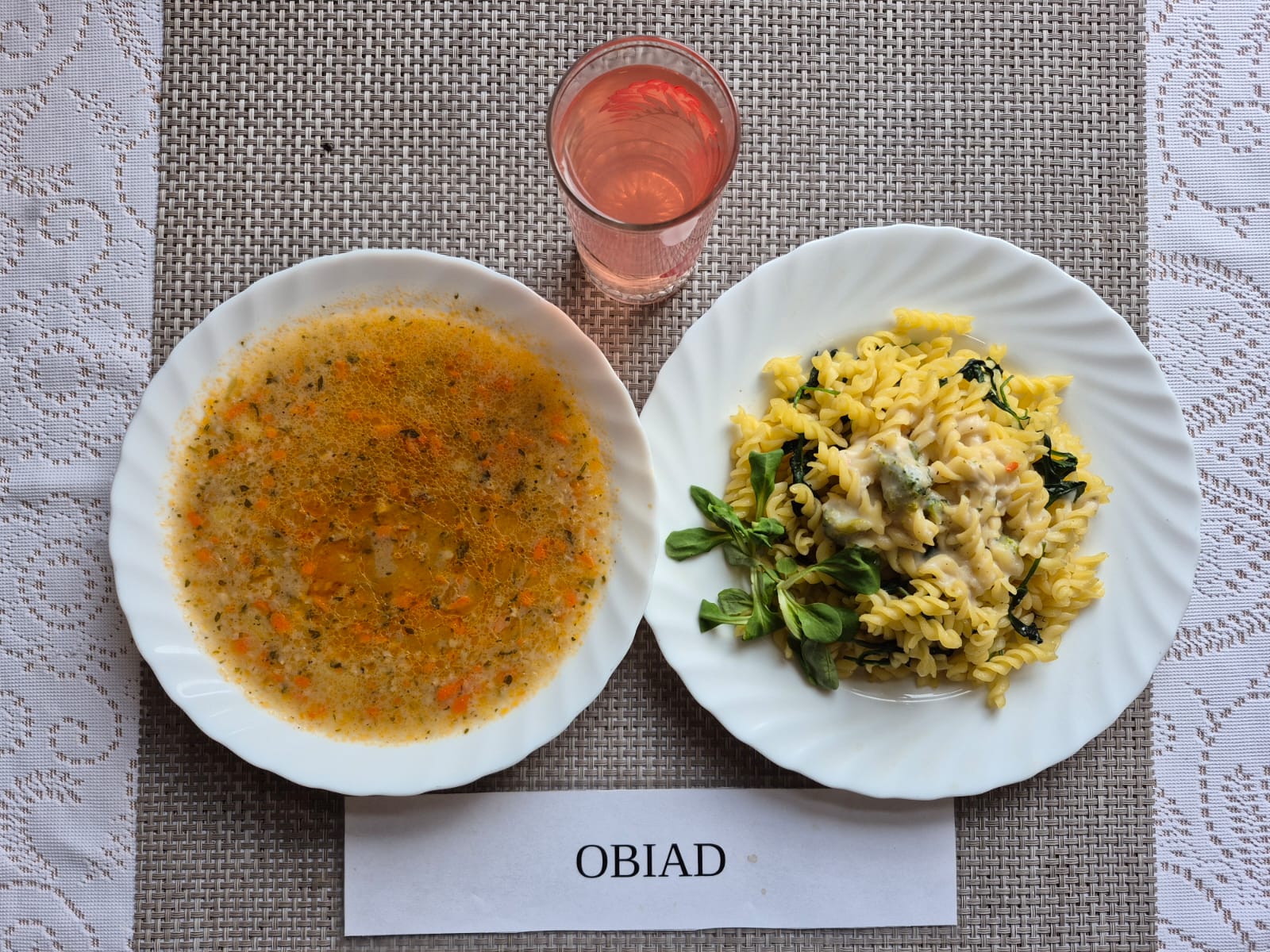 Na zdjęciu znajduję się posiłek w którego skład wchodzi Zupa krupnik z ziemniakami, Makaron z sosem śmietanowym brokułem i świeżym szpinakiem oraz kompot z jabłek