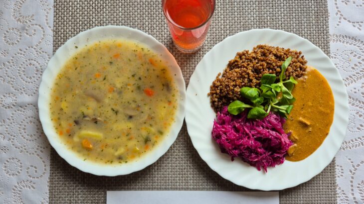 Na zdjęciu znajduję się posiłek w którego skład wchodzi Zupa ziemniaczano-pieczarkowa, Kasza gryczana, Gulasz wieprzowy, Surówka z czerwonej kapusty oraz kompot