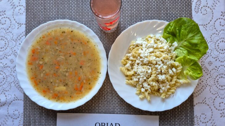 Na zdjęciu znajduję się posiłek w którego skład wchodzi Zupa grochowa z ziemniakami, Makaron z białym serem, Gruszka, kompot z jabłek